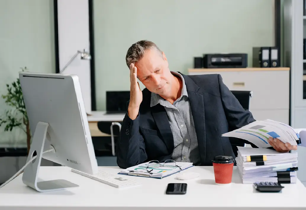 Frustrated person sitting on a desk