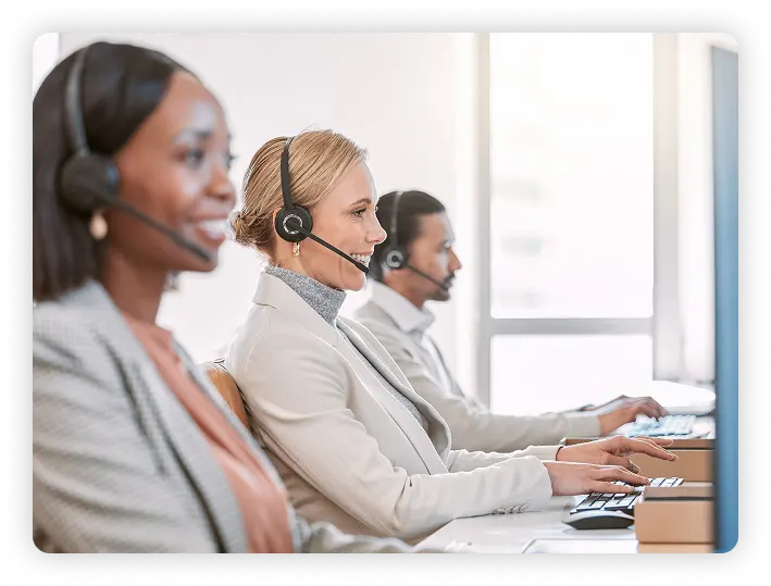 Three people on headsets working in a call center