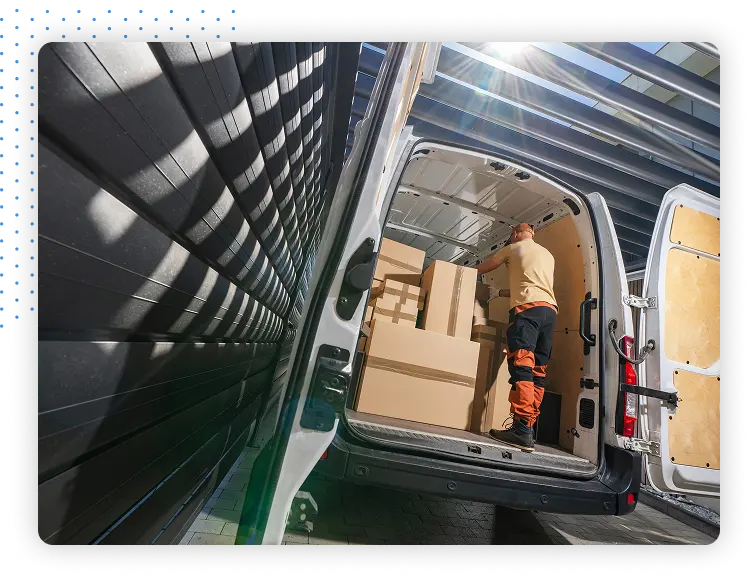 Worker loading boxes into back of van