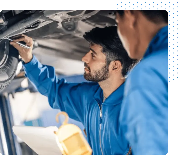 Car mechanic standing under a car